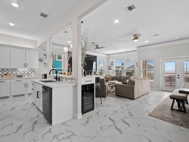 1018 Seashell Dr, Surfside Beach, TX 77541 - kitchen featuring wine cooler, light marble finish floors, dishwasher, plenty of natural light, and ornamental molding