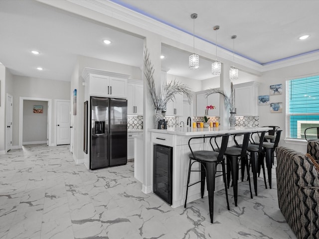 kitchen with wine cooler, a breakfast bar area, ornamental molding, decorative backsplash, and stainless steel refrigerator with ice dispenser