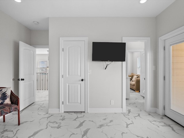 bedroom featuring recessed lighting, marble finish floor, and baseboards