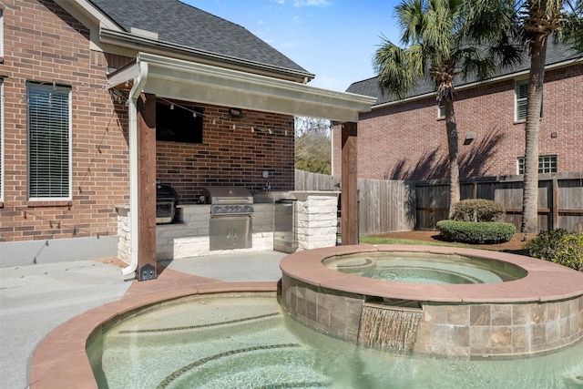 view of pool featuring area for grilling, an outdoor kitchen, an in ground hot tub, and fence