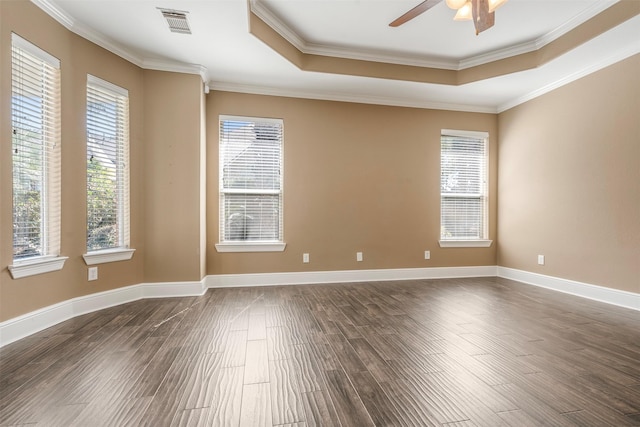 unfurnished room featuring visible vents, baseboards, dark wood finished floors, a tray ceiling, and a ceiling fan