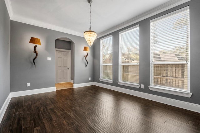 unfurnished dining area with baseboards, wood finished floors, arched walkways, and ornamental molding