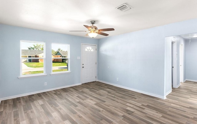 foyer featuring visible vents, ceiling fan, baseboards, and wood finished floors