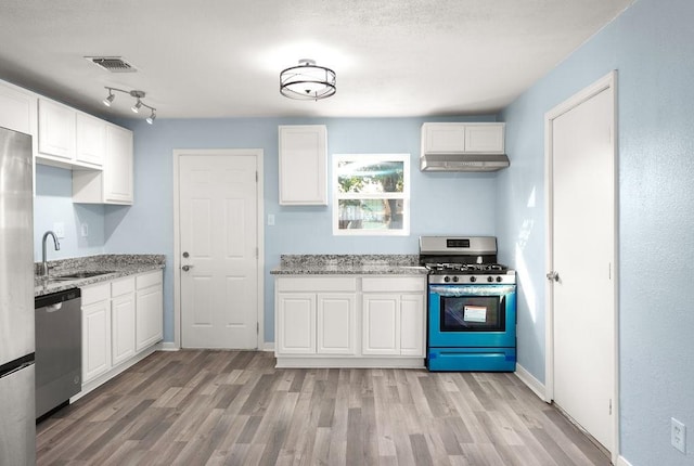 kitchen with light wood-type flooring, visible vents, a sink, stainless steel appliances, and white cabinets