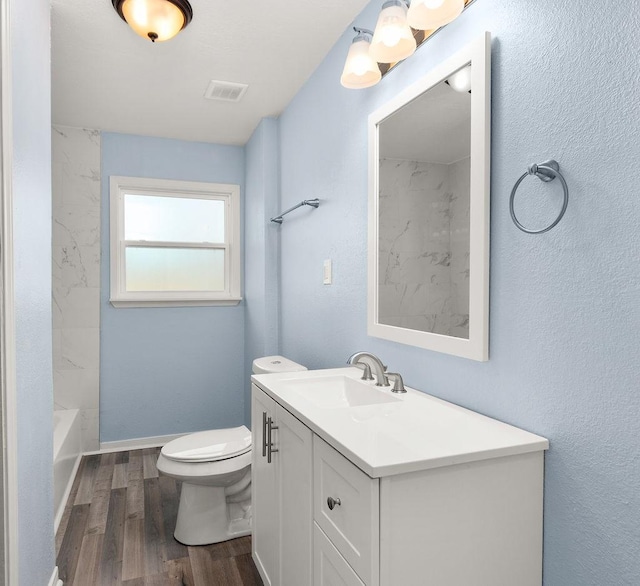 full bath featuring visible vents, toilet, wood finished floors, baseboards, and vanity