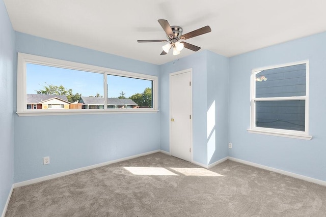 unfurnished room with a ceiling fan, carpet, and baseboards