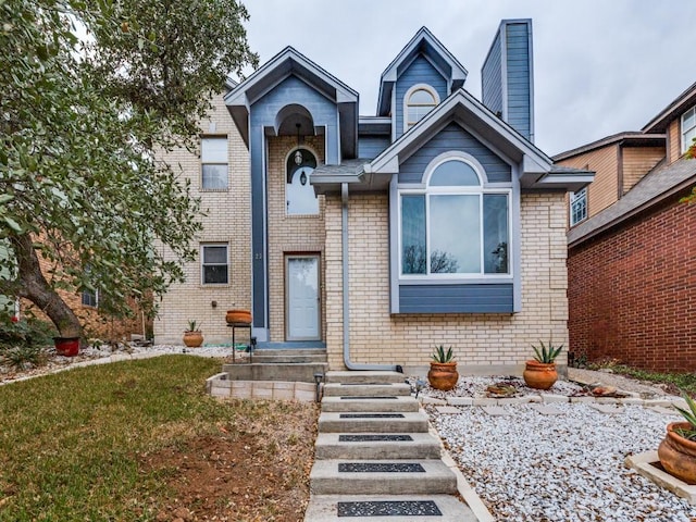 view of front of home featuring brick siding and a front lawn