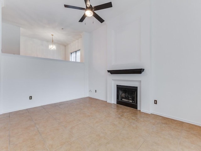 unfurnished living room with tile patterned floors, baseboards, a fireplace, and ceiling fan with notable chandelier