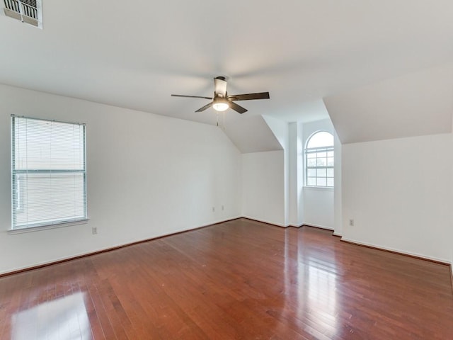 additional living space featuring a ceiling fan, vaulted ceiling, wood finished floors, and visible vents