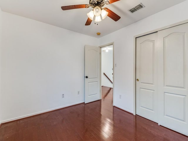 unfurnished bedroom with visible vents, baseboards, a closet, and hardwood / wood-style floors