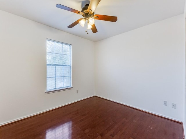 empty room featuring dark wood-type flooring and a ceiling fan