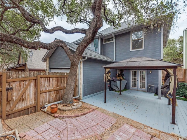 back of property with fence, a gazebo, french doors, a garage, and a patio area