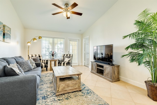 living room featuring light tile patterned floors, ceiling fan, baseboards, and lofted ceiling