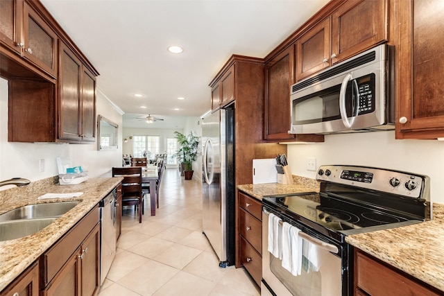 kitchen featuring light stone countertops, appliances with stainless steel finishes, and a sink