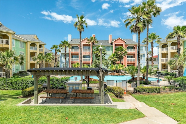 surrounding community featuring a swimming pool, a lawn, and fence