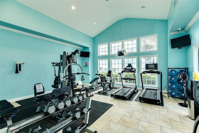 exercise room featuring baseboards and high vaulted ceiling