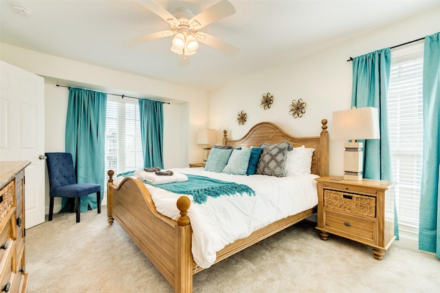 bedroom with a ceiling fan and light colored carpet