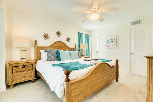 bedroom with baseboards, light colored carpet, visible vents, and ceiling fan