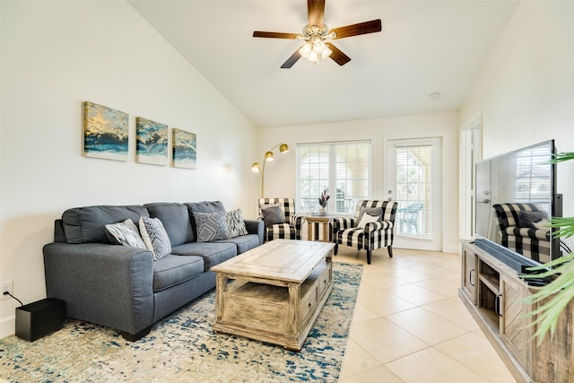 living area featuring lofted ceiling, light tile patterned flooring, and ceiling fan