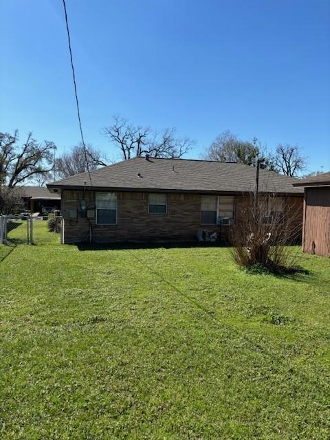 rear view of house with a yard and fence