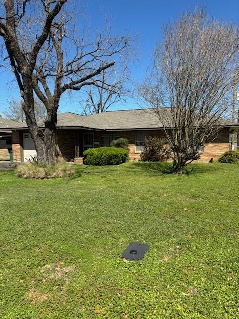 single story home with a front yard and a garage