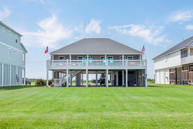 back of house featuring stairs, a lawn, a carport, and a shingled roof