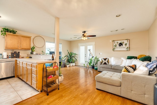 living room with visible vents, light wood-type flooring, and a ceiling fan