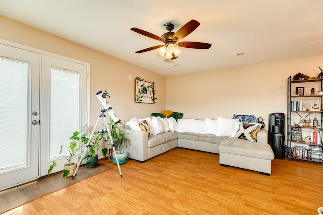 living room featuring a ceiling fan and light wood-type flooring