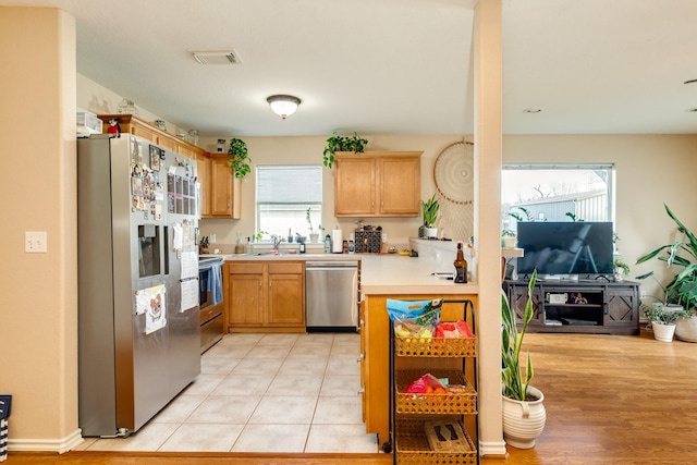 kitchen featuring stainless steel appliances, visible vents, light tile patterned flooring, and light countertops