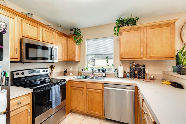 kitchen featuring a sink, appliances with stainless steel finishes, light tile patterned flooring, and light countertops