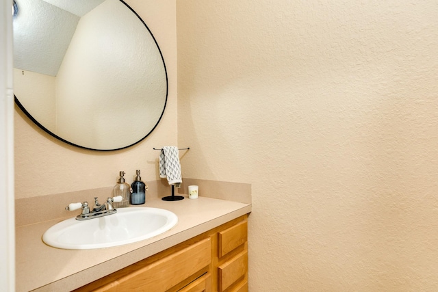 bathroom featuring vanity and a textured wall