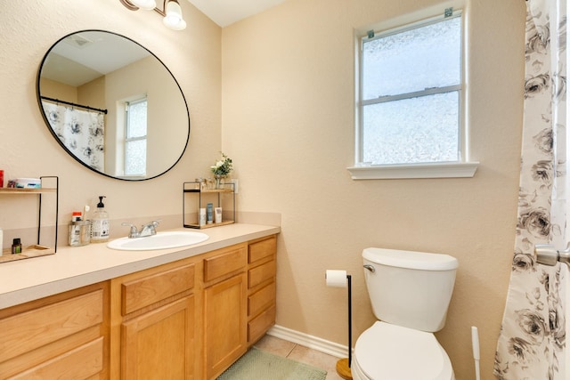 bathroom featuring tile patterned flooring, plenty of natural light, toilet, and vanity