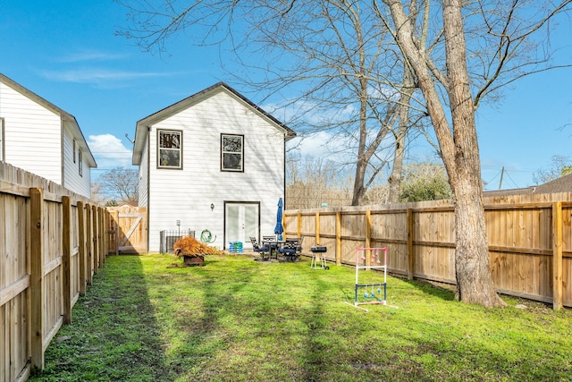 back of house featuring a lawn and a fenced backyard