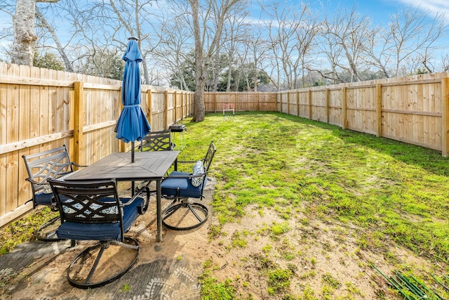 view of yard featuring outdoor dining space and a fenced backyard