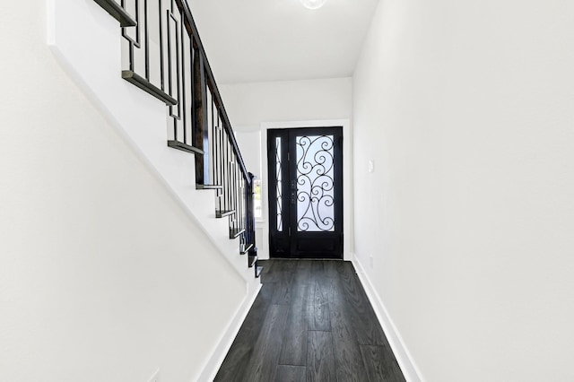 entrance foyer featuring stairs, baseboards, and dark wood-style flooring