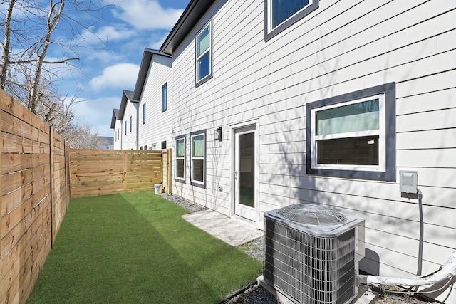 exterior space with central air condition unit and a fenced backyard