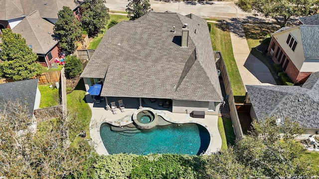 exterior space with an in ground hot tub, a patio area, and a fenced backyard