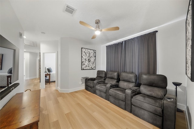 cinema with visible vents, baseboards, light wood-style floors, and a ceiling fan