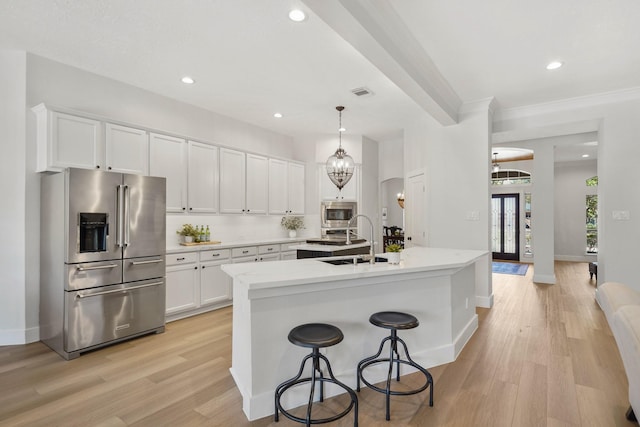 kitchen featuring visible vents, white cabinetry, stainless steel appliances, and a sink