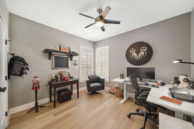 office featuring a ceiling fan, wood finished floors, baseboards, and a textured ceiling