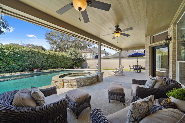 view of patio / terrace featuring an in ground hot tub, outdoor dining area, a fenced backyard, and a fenced in pool