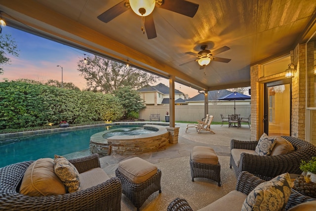 patio terrace at dusk with an in ground hot tub, a fenced backyard, and a fenced in pool