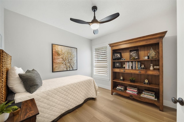 bedroom featuring ceiling fan, baseboards, and light wood-style flooring