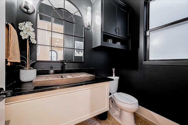 bathroom with vanity, toilet, and baseboards