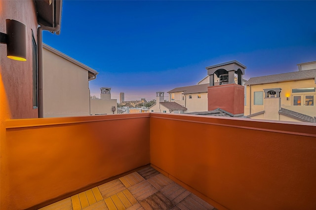 balcony at dusk featuring a view of city