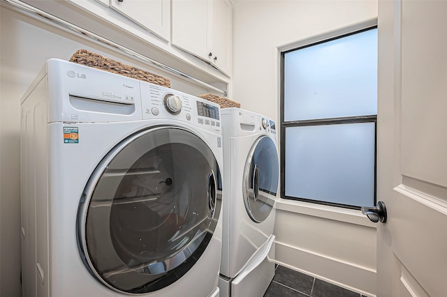 laundry area featuring tile patterned flooring, cabinet space, and washing machine and dryer