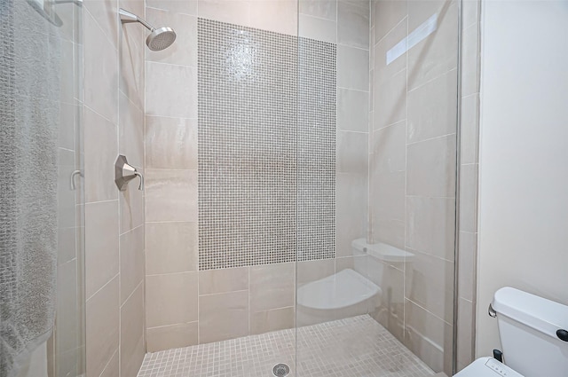 bathroom featuring a stall shower and toilet