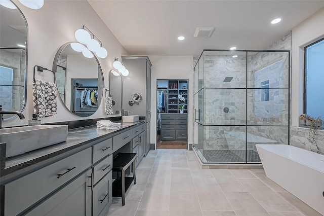 bathroom featuring a freestanding tub, visible vents, a stall shower, vanity, and a spacious closet