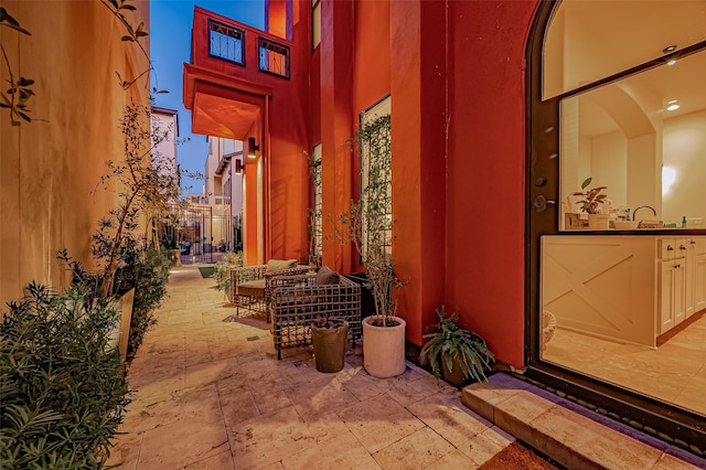 view of exterior entry with a patio area and a sink