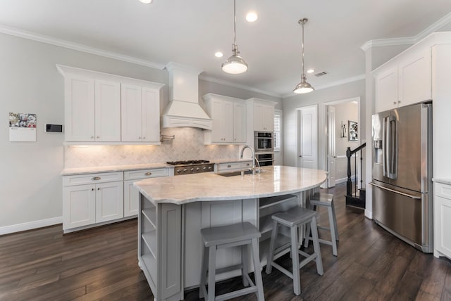 kitchen with tasteful backsplash, custom range hood, ornamental molding, stainless steel appliances, and a sink